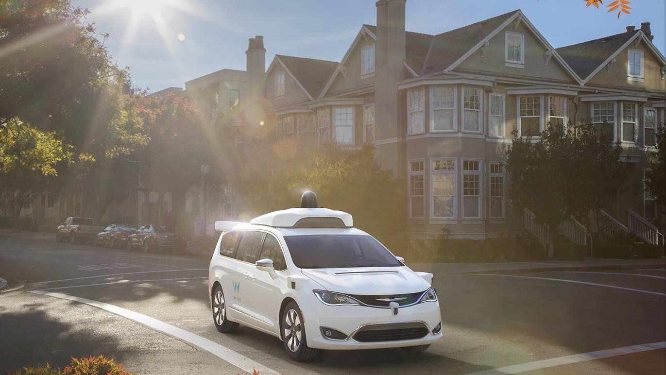 Image of a Waymo automated vehicle van in front of a house