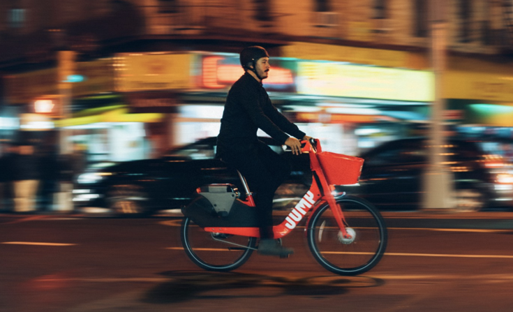 Person riding a red bike at night