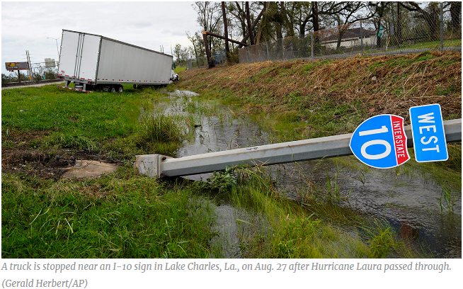A truck is stopped near an I-10 sign in Lake Charles, La., on Aug. 27 after Hurricane Laura passed through.