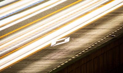 Image of a highway with a blur of vehicle lights over it 