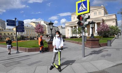A man wearing a face mask rides a scooter near the Bolshoi Theatre in Moscow on May 15, during a strict lockdown in Russia to stop the spread of COVID-19.